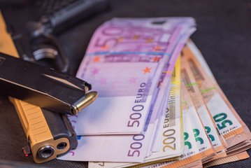 Black and gold gun pistol and money euros background