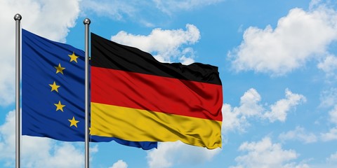 European Union and Germany flag waving in the wind against white cloudy blue sky together. Diplomacy concept, international relations.
