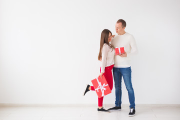 Christmas, holidays, Valentine's day and birthday concept - Happy man and woman holds boxes with gifts on white background with copy space