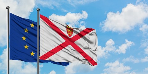 European Union and Jersey flag waving in the wind against white cloudy blue sky together. Diplomacy concept, international relations.