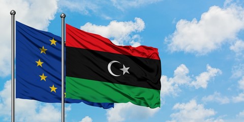 European Union and Libya flag waving in the wind against white cloudy blue sky together. Diplomacy concept, international relations.