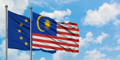 European Union and Malaysia flag waving in the wind against white cloudy blue sky together. Diplomacy concept, international relations.