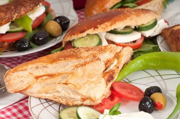 Breakfast consisting of olives, cheese, tomatoes, peppers and sandwiches