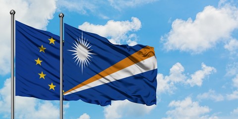 European Union and Marshall Islands flag waving in the wind against white cloudy blue sky together. Diplomacy concept, international relations.