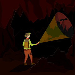 A young man stands in a dark cave and illuminates his path with a lantern. Illustration in a flat style.