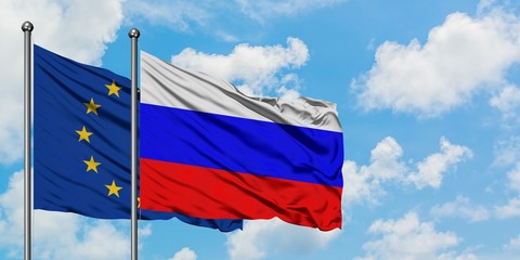 European Union and Russia flag waving in the wind against white cloudy blue sky together. Diplomacy concept, international relations.