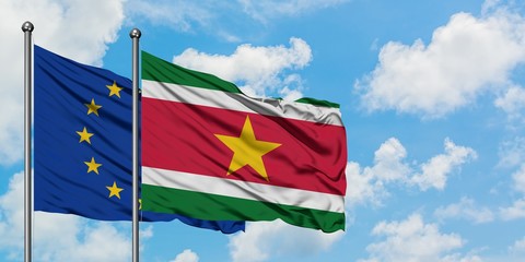 European Union and Suriname flag waving in the wind against white cloudy blue sky together. Diplomacy concept, international relations.
