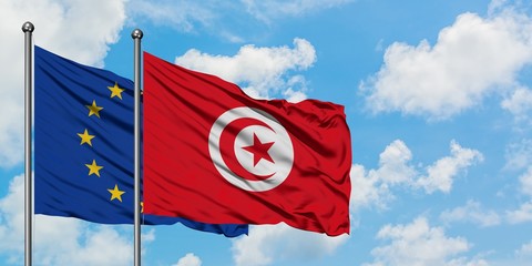 European Union and Tunisia flag waving in the wind against white cloudy blue sky together. Diplomacy concept, international relations.