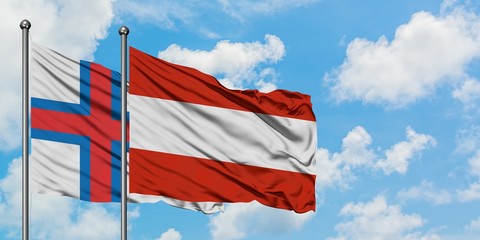 Faroe Islands and Austria flag waving in the wind against white cloudy blue sky together. Diplomacy concept, international relations.