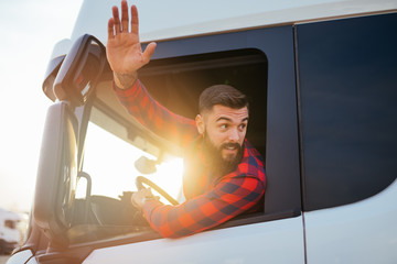 Young handsome bearded man driving his truck.