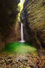 Fototapeta na wymiar Picturesque view of the rocky amphitheatre with a green pool and a white beam of water. 15-metre-high Kozjak Waterfall (Slap Kozjak). Protected natural treasure. National Park of Triglav, Soca valley