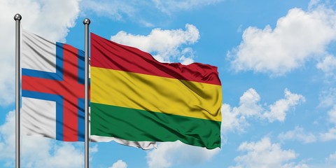 Faroe Islands and Bolivia flag waving in the wind against white cloudy blue sky together. Diplomacy concept, international relations.