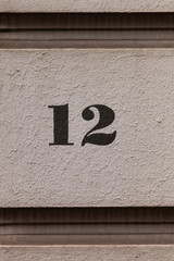 black painted number 12 on white wall