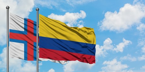 Faroe Islands and Colombia flag waving in the wind against white cloudy blue sky together. Diplomacy concept, international relations.