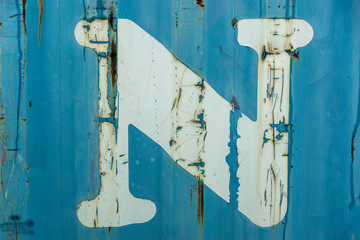 metal surface with rust and peeling blue and white paint