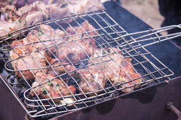 Barbecue grilling. Lamb meat on the bone on coals and smoke from coals. Summer outdoor activities.