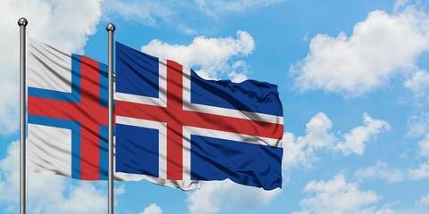 Faroe Islands and Iceland flag waving in the wind against white cloudy blue sky together. Diplomacy concept, international relations.