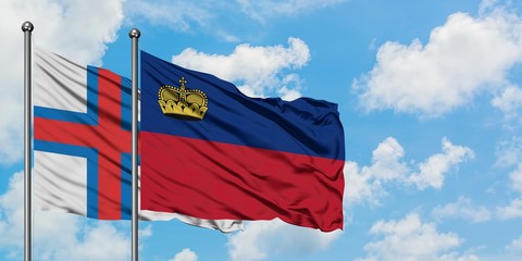 Faroe Islands and Liechtenstein flag waving in the wind against white cloudy blue sky together. Diplomacy concept, international relations.