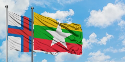 Faroe Islands and Myanmar flag waving in the wind against white cloudy blue sky together. Diplomacy concept, international relations.