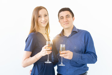 Man and woman celebrating Christmas or New Year eve party with glasses of champagne on white background