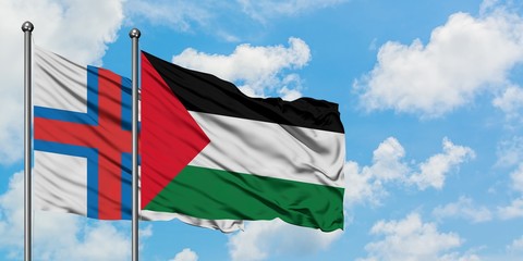 Faroe Islands and Palestine flag waving in the wind against white cloudy blue sky together. Diplomacy concept, international relations.