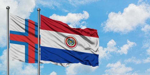 Faroe Islands and Paraguay flag waving in the wind against white cloudy blue sky together. Diplomacy concept, international relations.