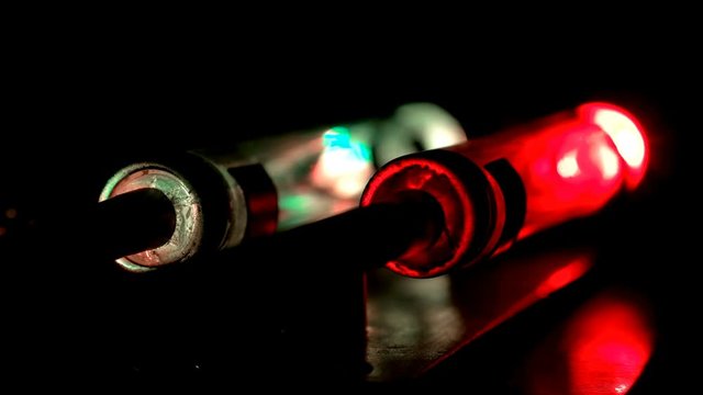 Two glowing flasks, one blinking red. It looks like a device with two safety power blocks, one blinks red, warning about overload, close-up