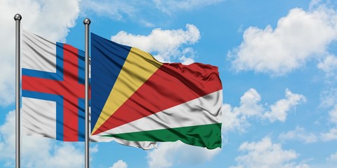 Faroe Islands and Seychelles flag waving in the wind against white cloudy blue sky together. Diplomacy concept, international relations.