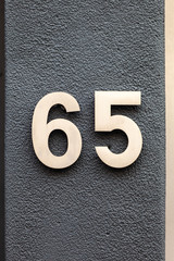 brass number 65 on black wall