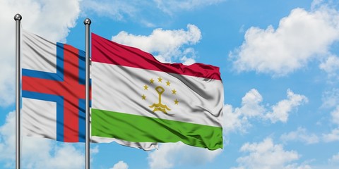 Faroe Islands and Tajikistan flag waving in the wind against white cloudy blue sky together. Diplomacy concept, international relations.