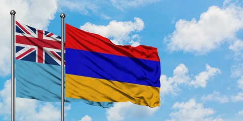 Fiji and Armenia flag waving in the wind against white cloudy blue sky together. Diplomacy concept, international relations.