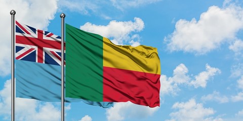 Fiji and Benin flag waving in the wind against white cloudy blue sky together. Diplomacy concept, international relations.
