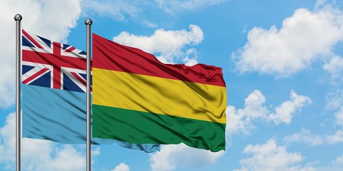 Fiji and Bolivia flag waving in the wind against white cloudy blue sky together. Diplomacy concept, international relations.