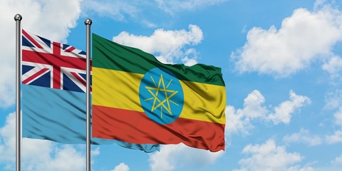 Fiji and Ethiopia flag waving in the wind against white cloudy blue sky together. Diplomacy concept, international relations.