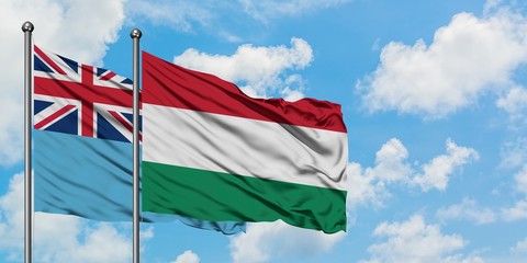 Fiji and Hungary flag waving in the wind against white cloudy blue sky together. Diplomacy concept, international relations.