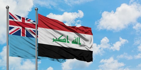 Fiji and Iraq flag waving in the wind against white cloudy blue sky together. Diplomacy concept, international relations.