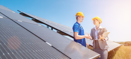 Construction worker and investor in solar power plant shaking hands