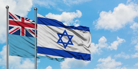 Fiji and Israel flag waving in the wind against white cloudy blue sky together. Diplomacy concept, international relations.