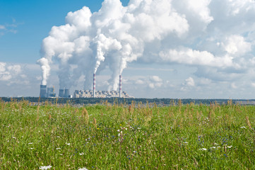 Coal-fired power station with steam billowing from high chimneys. Power plant in Bełchatów, Poland