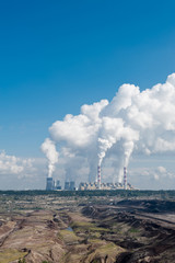 Power plant and coal mine in Bełchatów, Poland. Coal-fired power station with steam billowing from high chimneys