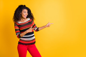 Portrait of her she nice attractive lovely cheerful glad wavy-haired girl in knitted sweater pointing aside solution follow subscribe isolated on bright vivid shine vibrant yellow color background