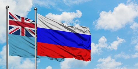 Fiji and Russia flag waving in the wind against white cloudy blue sky together. Diplomacy concept, international relations.