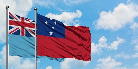 Fiji and Samoa flag waving in the wind against white cloudy blue sky together. Diplomacy concept, international relations.