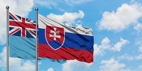Fiji and Slovakia flag waving in the wind against white cloudy blue sky together. Diplomacy concept, international relations.