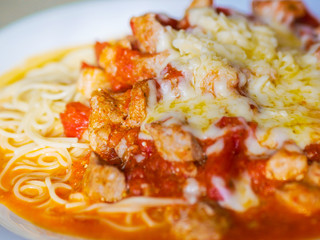 pasta with meat and tomatoes on a white plate