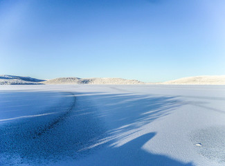 Filled with snow, but not completely frozen forest lake on a frosty day in the north of Russia.