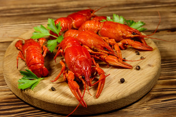 Boiled crayfish on cutting board on wooden table
