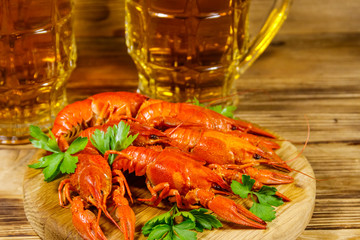 Boiled crayfish and two mugs of beer on a wooden table