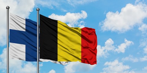 Finland and Belgium flag waving in the wind against white cloudy blue sky together. Diplomacy concept, international relations.