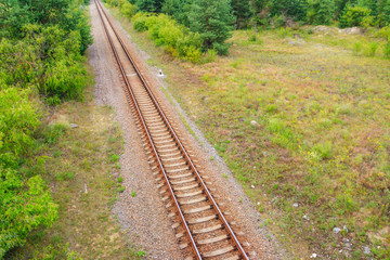 Obraz premium Aerial view of railroad track through a green pine forest